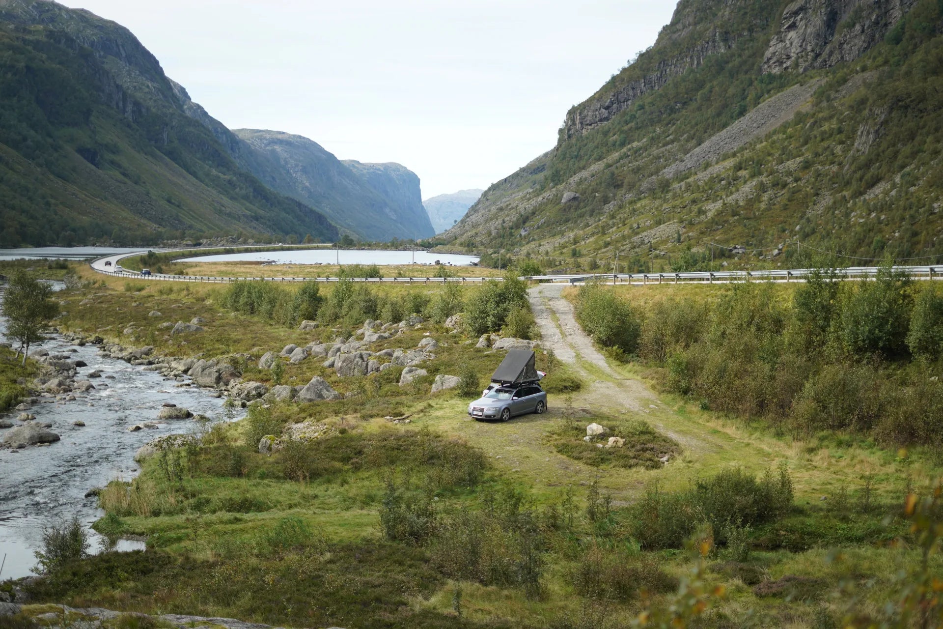 Auto mit Altoura Dachzelt am Fjord in norwegischer Berglandschaft